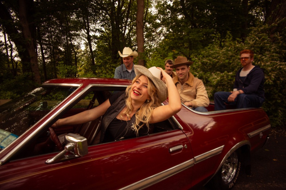 Candy and her band with a vintage car