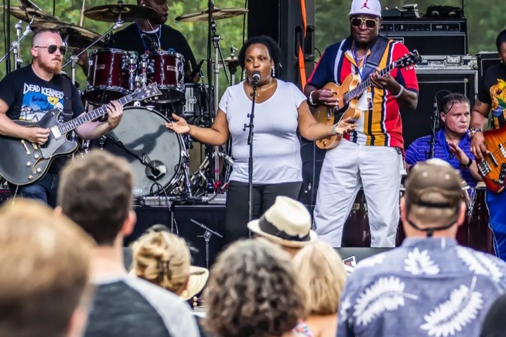 Cinnamon Jones singing with her band at an outdoor concert